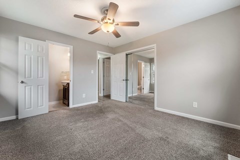 a living room with carpet and a ceiling fan