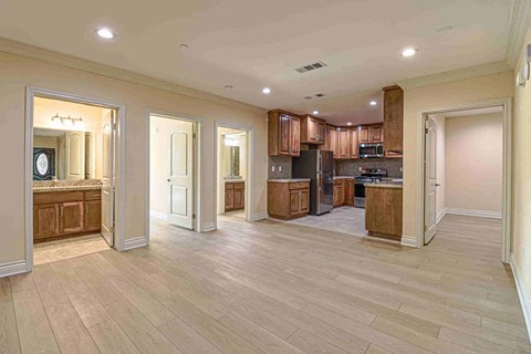 a kitchen and living room with wood floors and wooden cabinets