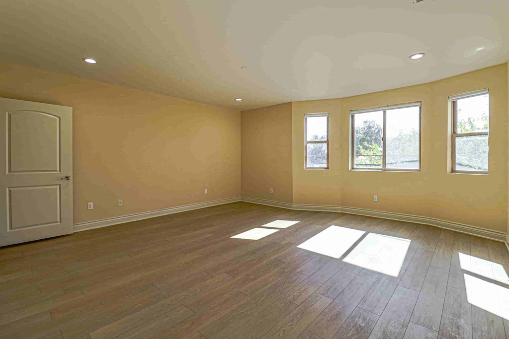 an empty living room with wooden floors and a door