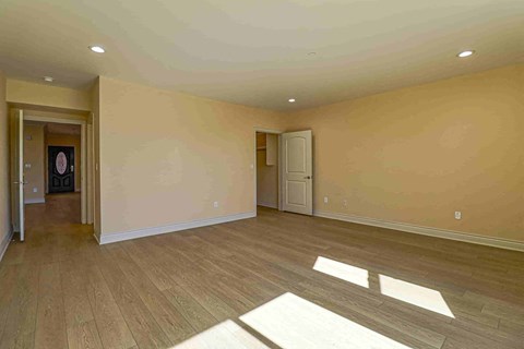 an empty living room with wooden floors and a white door