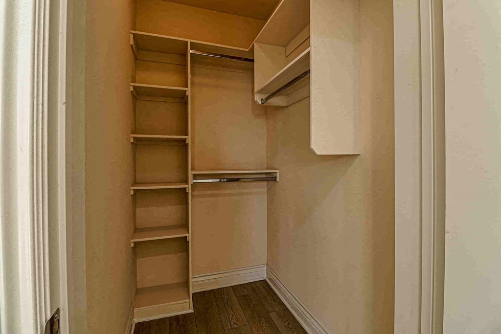 a walk in closet with shelves and a white door