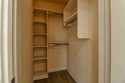 a walk in closet with shelves and a white door