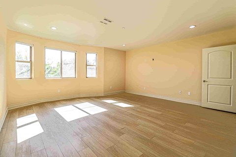 an empty living room with wooden floors and a door