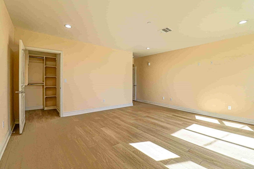 an empty living room with a door to a closet