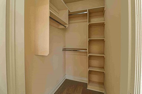 a walk in closet with shelves and drawers