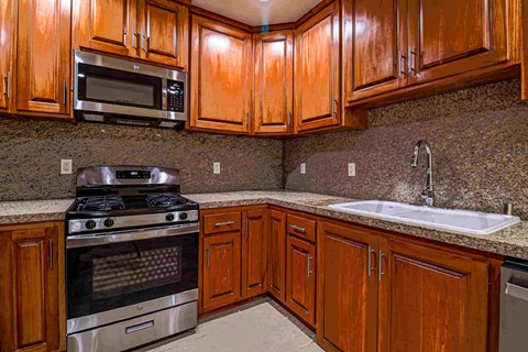 a kitchen with wooden cabinets and stainless steel appliances