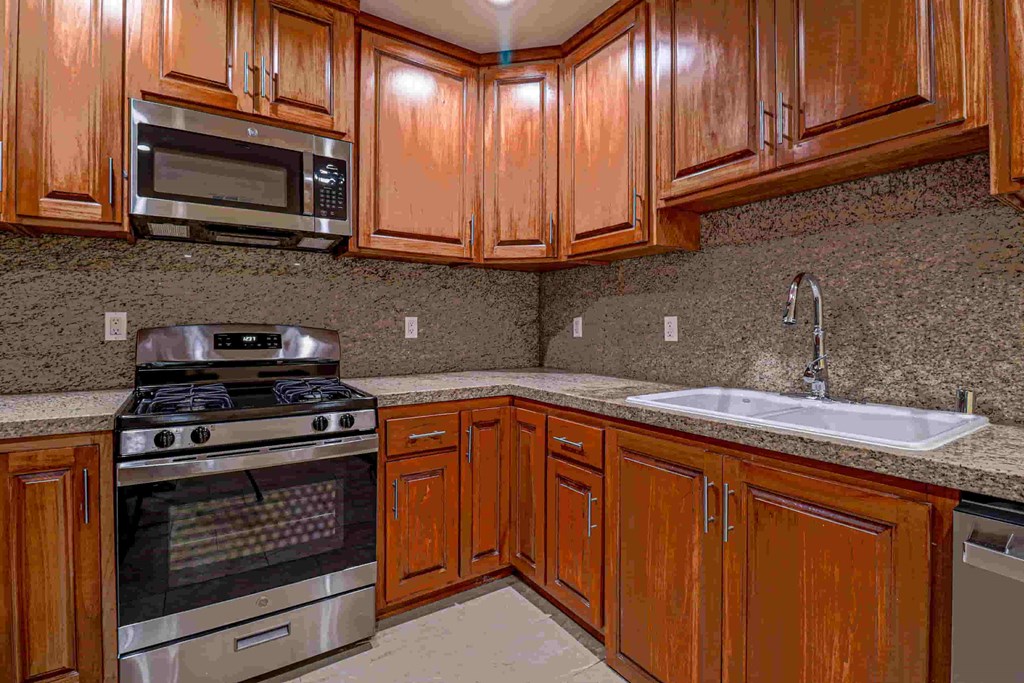 a kitchen with wooden cabinets and stainless steel appliances