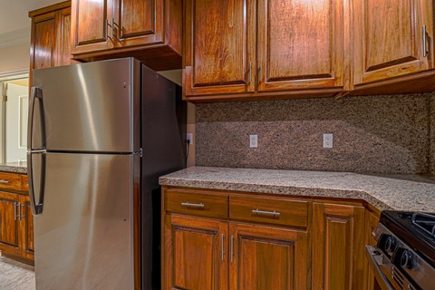 a kitchen with wooden cabinets and a stainless steel refrigerator