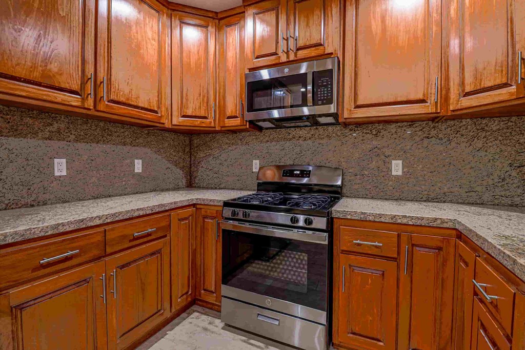 a kitchen with wood cabinets and stainless steel appliances