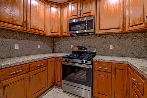 a kitchen with wood cabinets and stainless steel appliances