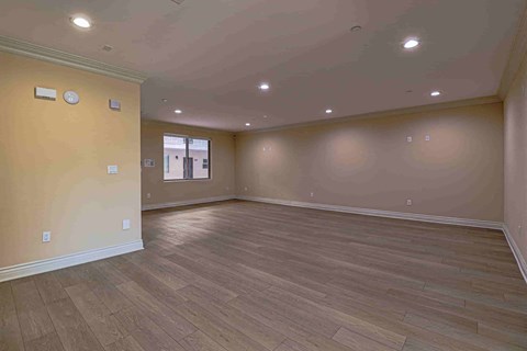 an empty living room with wood floors and a window