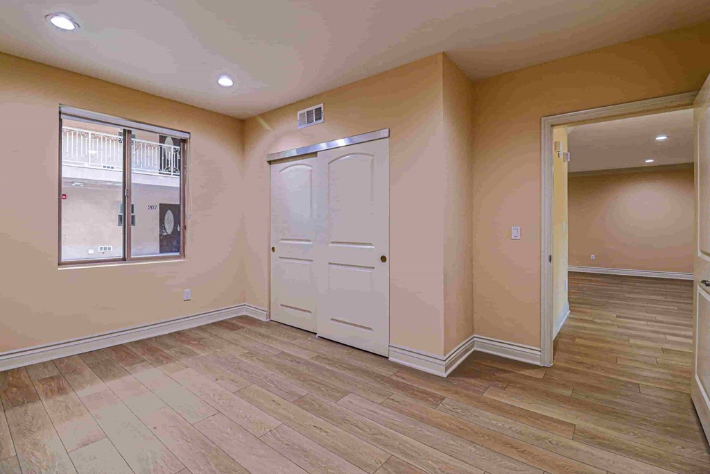 an empty living room with a door and a window