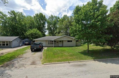 A Google street view image of a residential area with houses and a parked car.