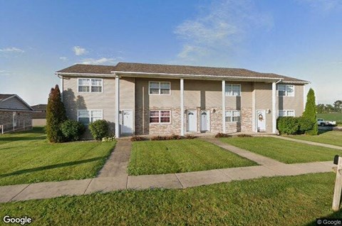A two-story house with a front yard and a driveway.