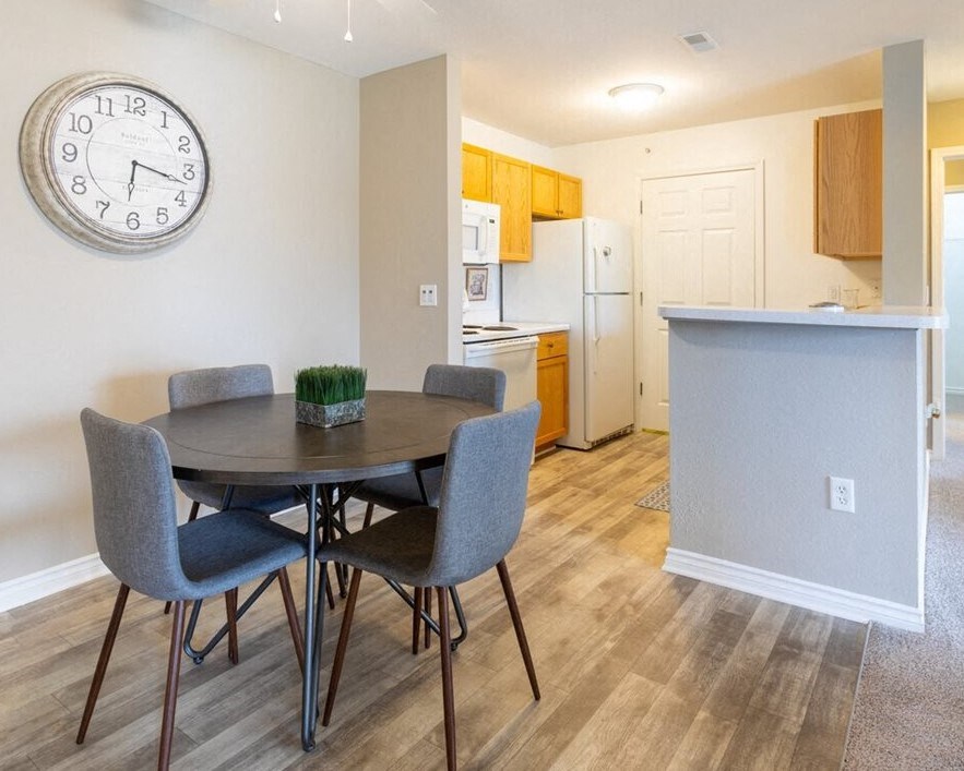 a dining room and kitchen with a large clock on the wall