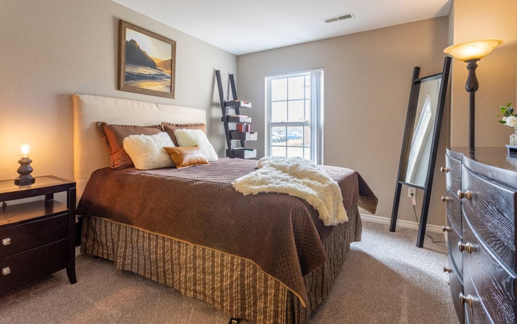 a bedroom with a bed and a dresser and a window