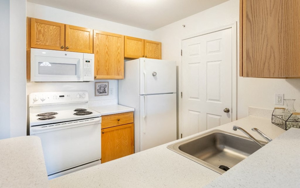 a kitchen with white appliances and wooden cabinets