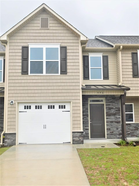 A two-story house with a white garage door.