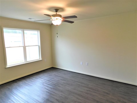 A room with a ceiling fan and a window.