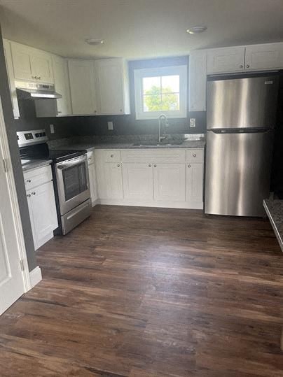 a kitchen with white cabinets and a stainless steel refrigerator