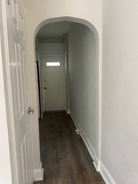 a hallway with an arched doorway and a white door