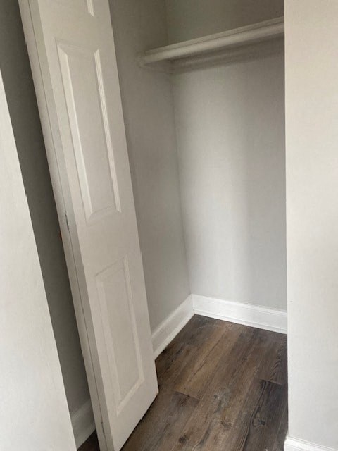 a white closet with a white door and a wooden floor