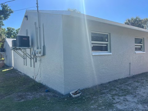 a white house with an air conditioning unit on the side of it