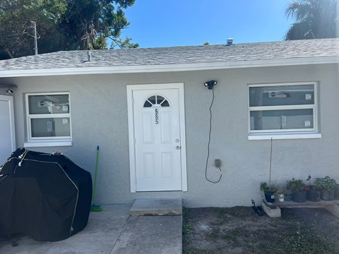 a white house with a white door and a tent in front of it