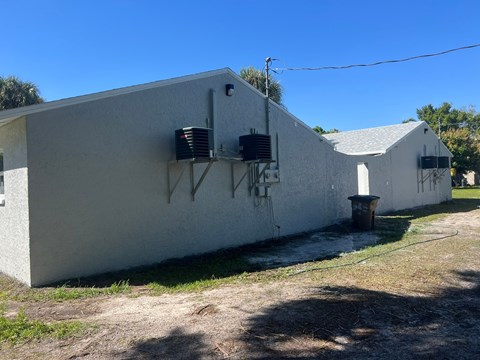 a white building with two air conditioning units on the side of it