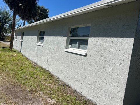 a side view of a white building with two windows