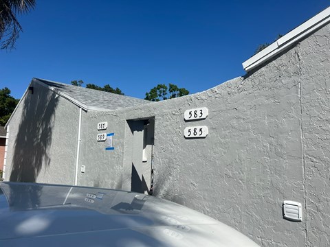 the side of a building with street numbers on it and a car