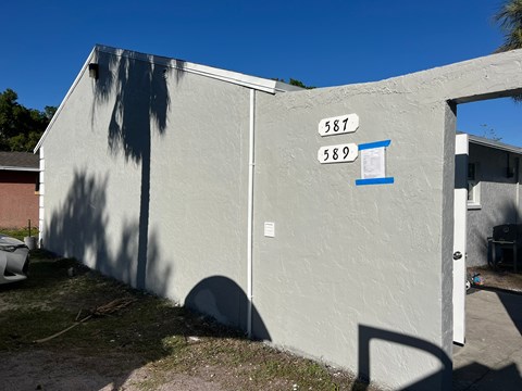 the side of a building with a street sign on it