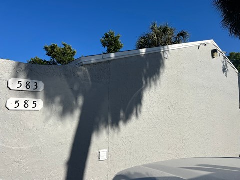 the shadow of a street sign on the side of a building
