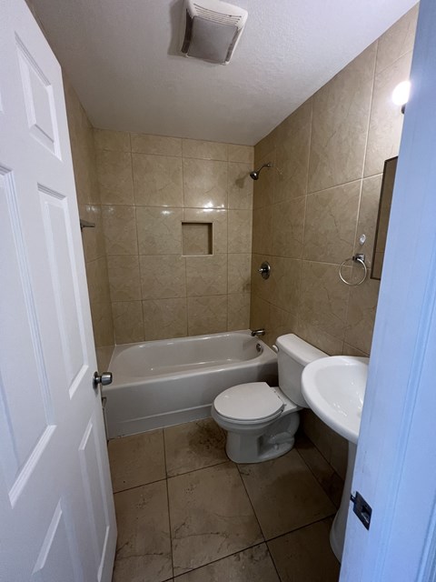 a bathroom with a toilet and a sink and a bath tub