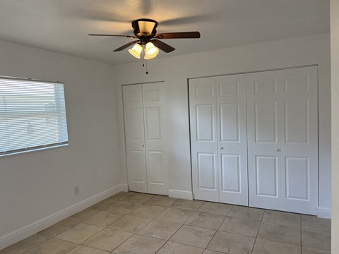 a room with two closets and a ceiling fan