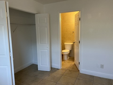 an empty bathroom with a toilet and a closet
