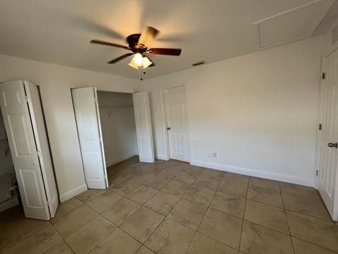 the living room has a ceiling fan and a tiled floor