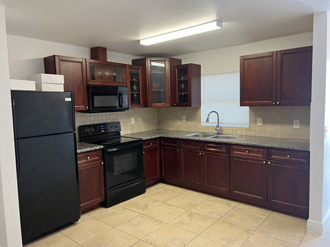 a kitchen with black appliances and wooden cabinets