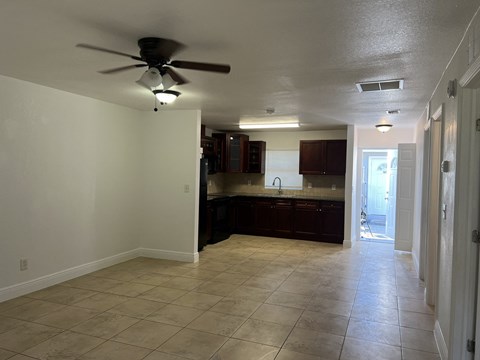 an empty kitchen with a ceiling fan and a tiled floor