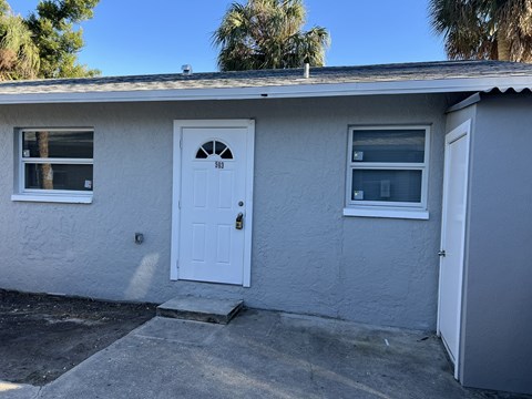 the front of a white house with a white door