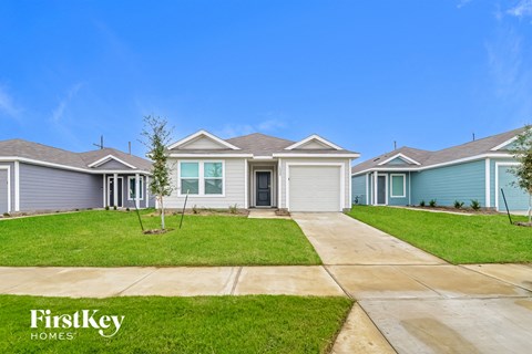 a blue and white house with a sidewalk and grass
