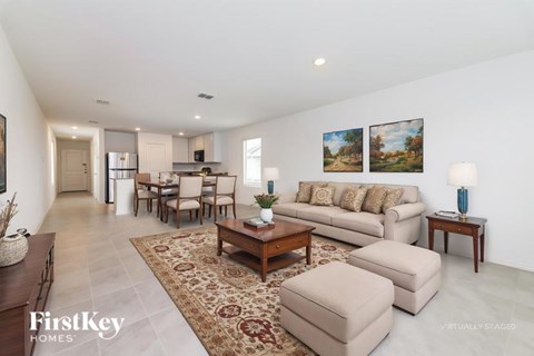A spacious living room with a sofa set, a coffee table, and a rug.