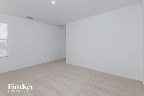 the living room of an apartment with white walls and carpet