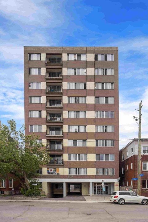 A tall building with a car parked in front of it.