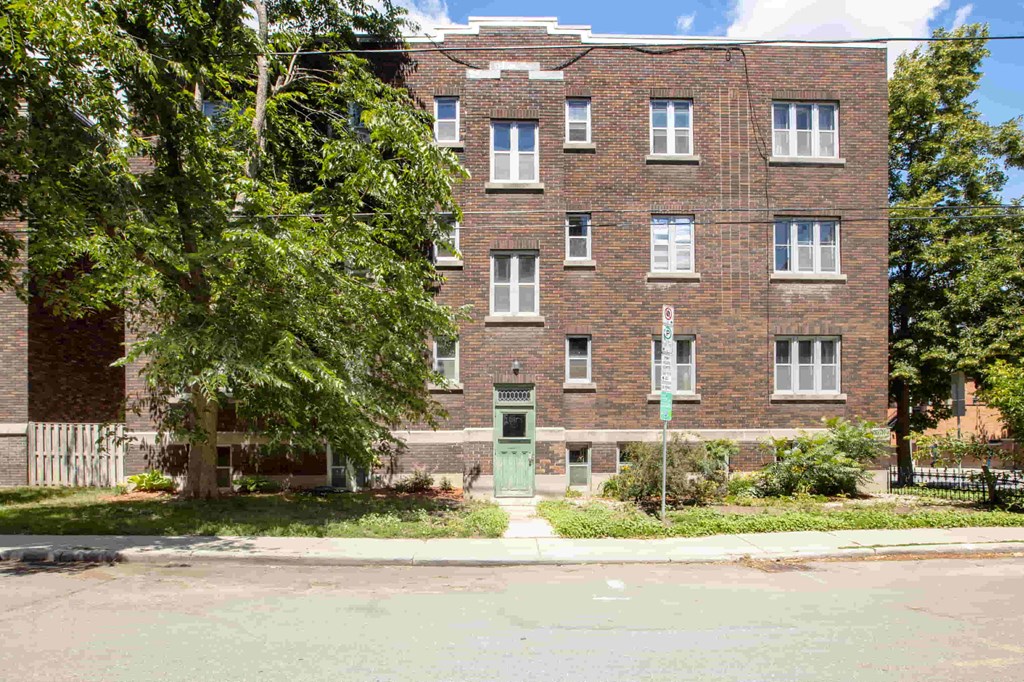 a red brick apartment building with a green door