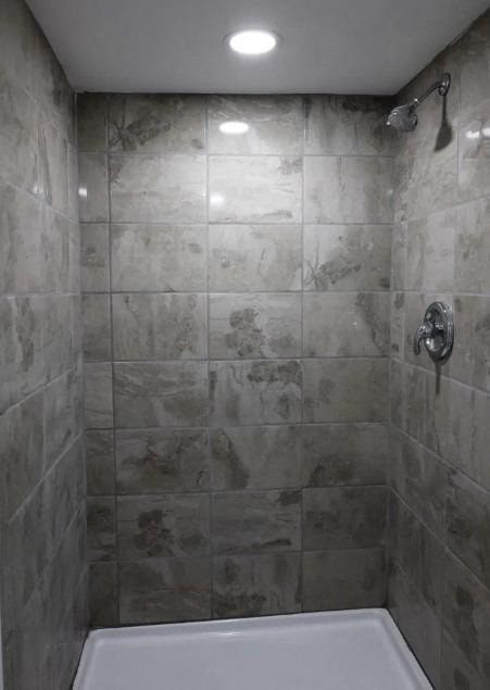a tiled bathroom with a shower and a sink