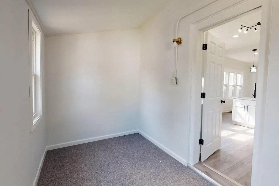 a white room with a white door and a carpet