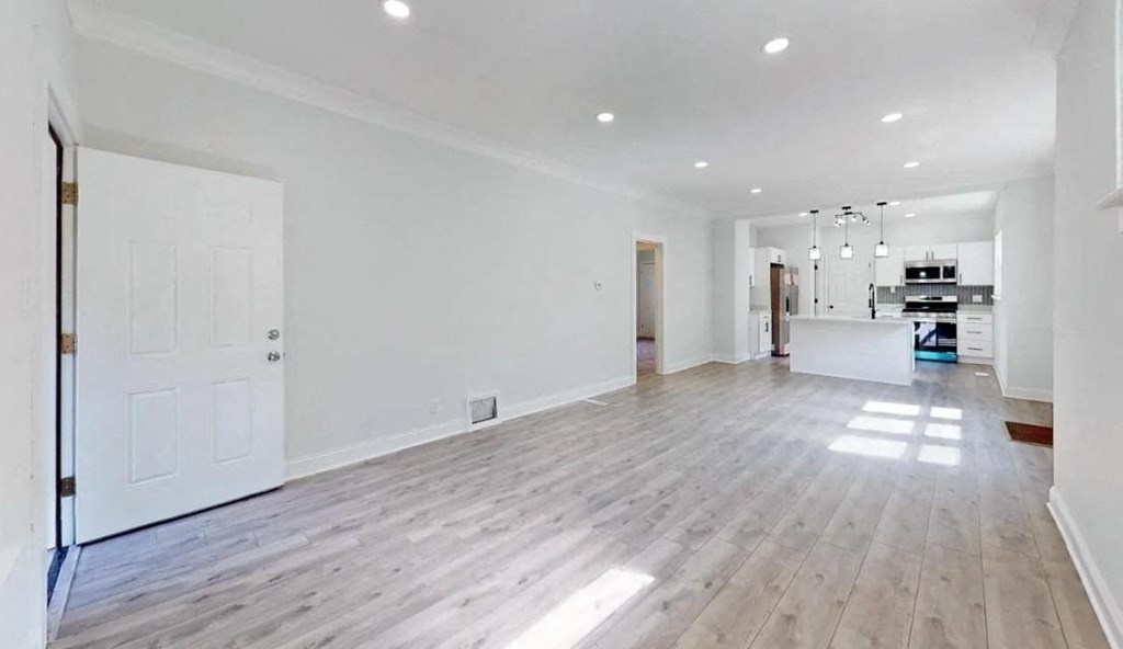 an empty living room with white walls and wood floors
