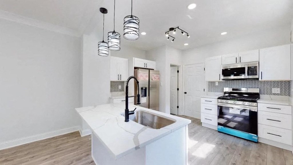 a white kitchen with a sink and a stove