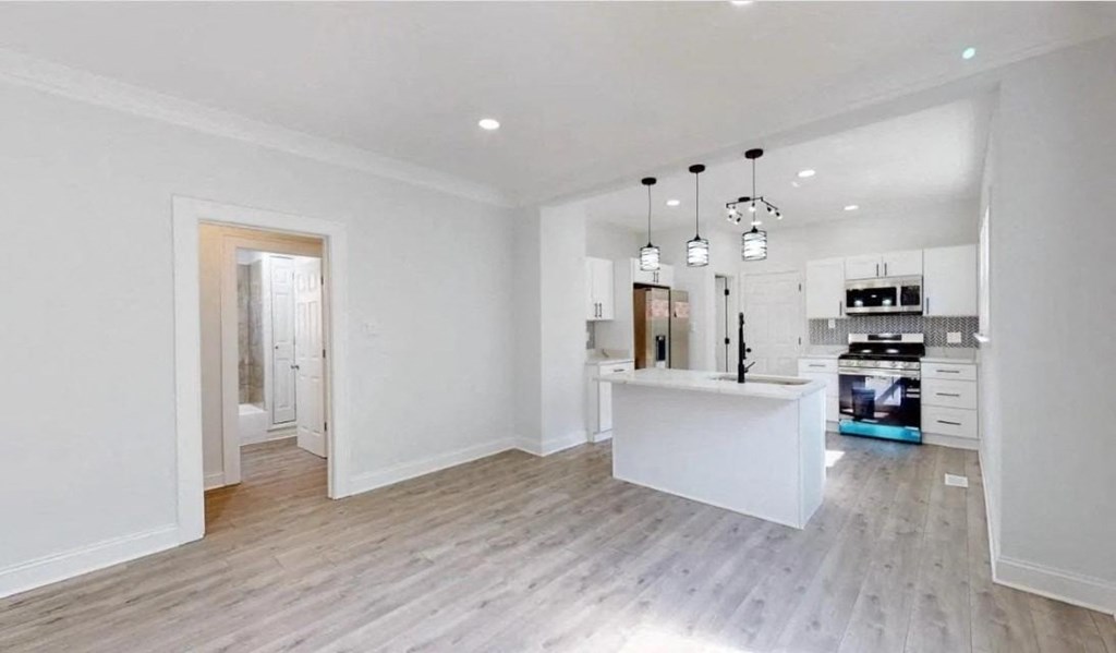 an open kitchen and living room with a white counter top and a kitchen island